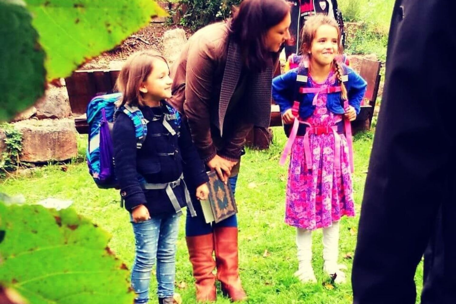 Kinder mit Schulranzen im Kreis im Grünen - bewusster Übergang in die Schulzeit durch ein Einschulungsritual