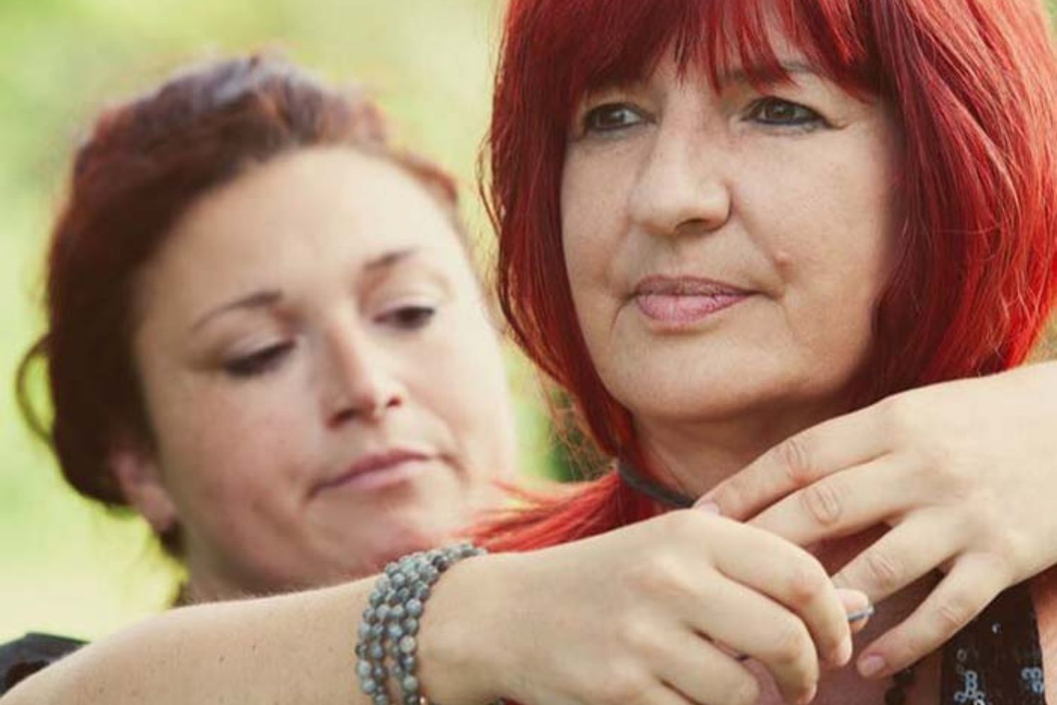 Zwei Frauen in einem intensiven Moment während eines Rituals zur Sprachlosigkeit, eine hält die andere von hinten, verbunden und präsent