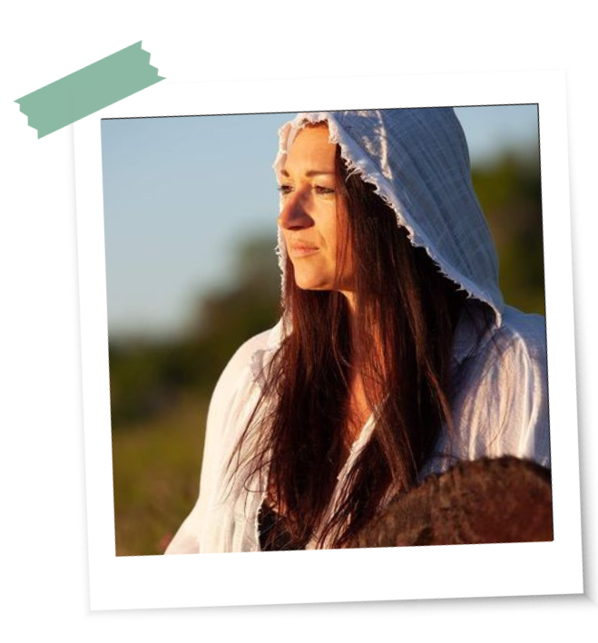 Beltane und Ritualbilder Nina In einem Beltane Ritual trommelt eine Frau mit Blick in die Weite und weißer Kapuze