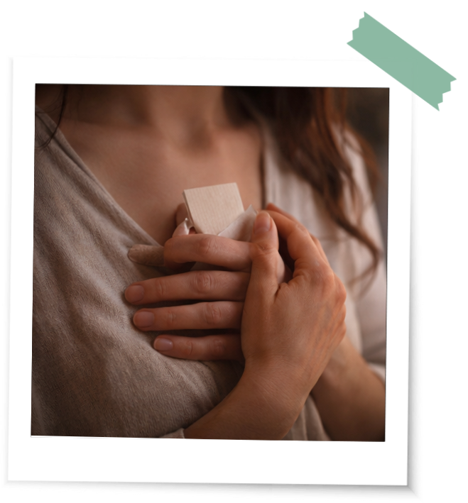 Frau hält einen Zettel mit ihrem letzten Rauhnachtswunsch ans Herz in einem Ritual der 13 Wünsche