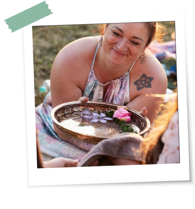 blessingway-schwangerschaft-definition-ritual Frauen reichen sich eine Wasserschale mit Blumen als Teil eines Blessingway-Rituals