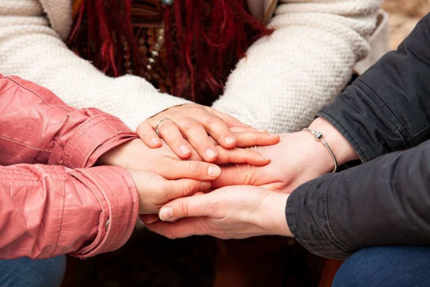 Mehrere Hände liegen übereinander - Symbol für Verbindung, Familie und gemeinsame Rituale