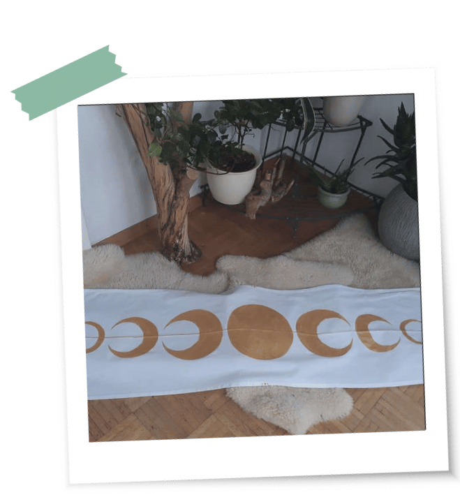 Ein weißes Tuch mit goldenen Mondphasen liegt als eines der ersten LaLuna-Ritualtücher auf einem Fell vor Ritualgegenständen