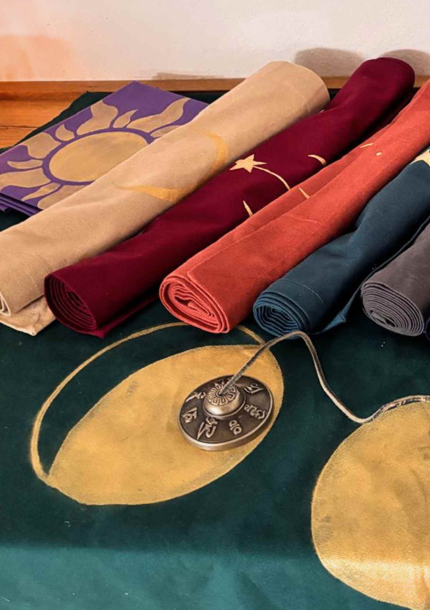 Verschiedene LaLuna-Ritualtücher in petrol, beige, rot und lila liegen zur Auswahl bereit