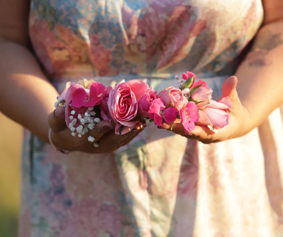 Blessingway Stuttgart Ritualbegleitung Pinkfarbener Blumenkrank in den Händen von Nina Maria Doulgeris bei einem Blessingway-Ritual